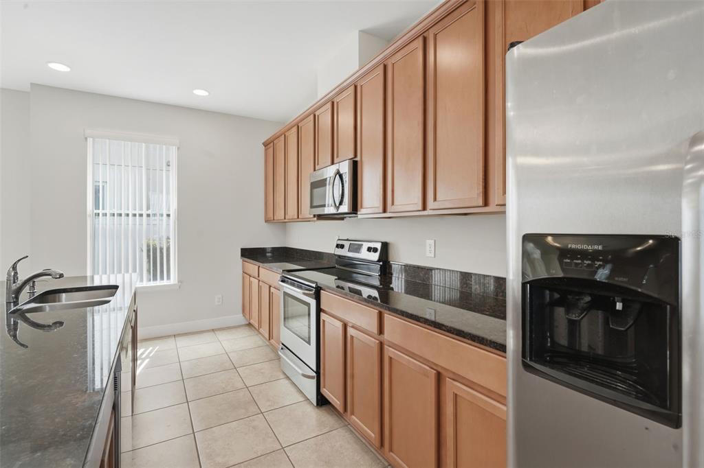 11486 Misty Oak Alley Windermere, FL 34786 - Photo 21 of 47 a kitchen with stainless steel appliances granite countertop a stove a sink and a microwave