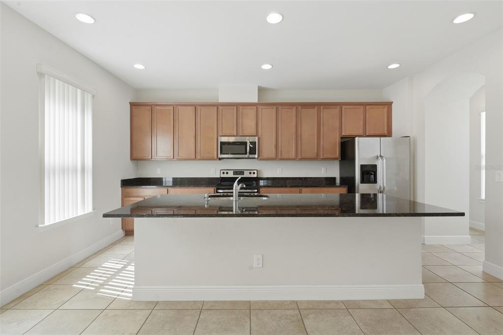 11486 Misty Oak Alley Windermere, FL 34786 - Photo 22 of 47 a large kitchen with stainless steel appliances granite countertop a sink and a refrigerator