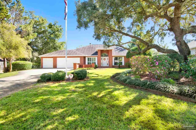 a view of a house with a big yard and large trees
