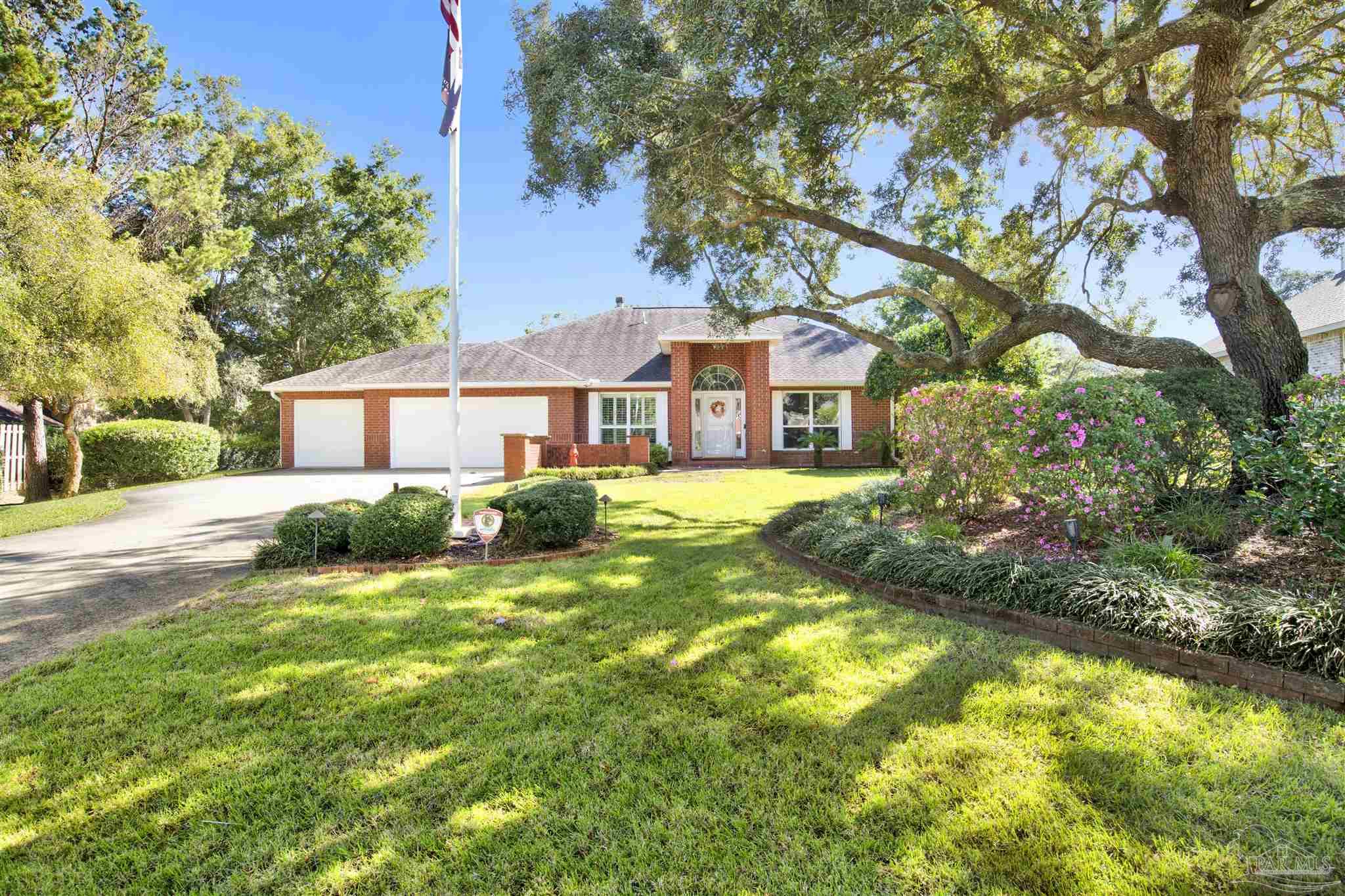 a view of a house with a big yard and large trees