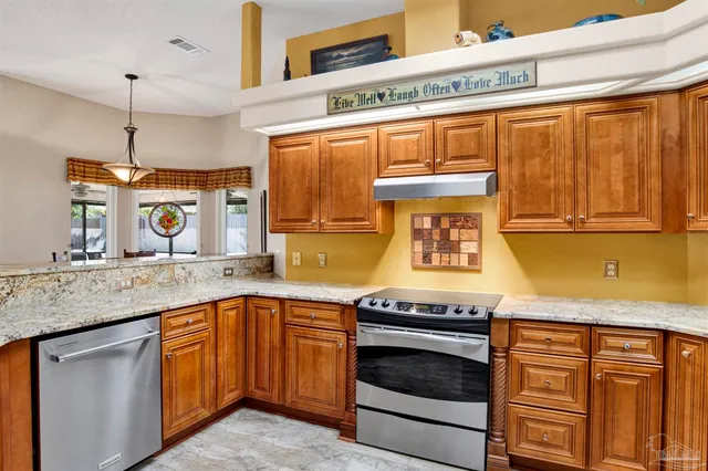 a kitchen with granite countertop stainless steel appliances and wooden cabinets