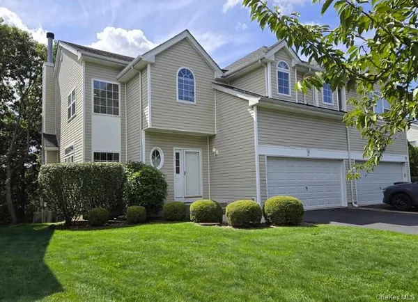a view of a house with a yard and a large tree