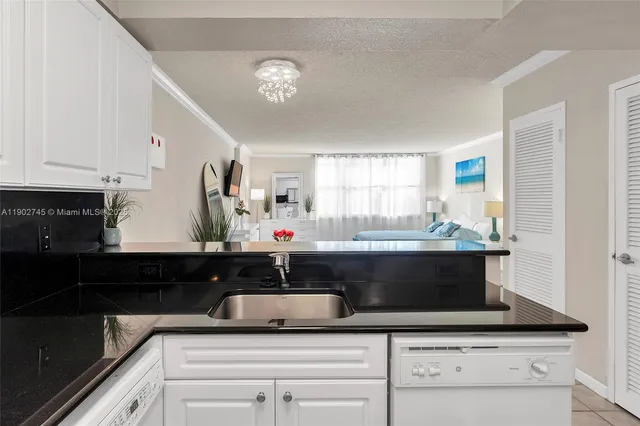 a kitchen with granite countertop white cabinets and black appliances