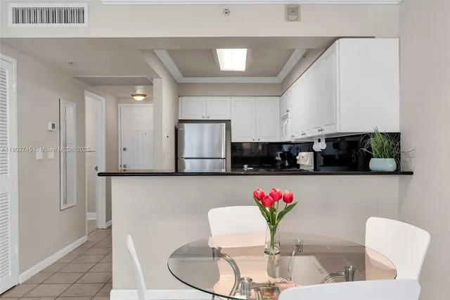 a view of kitchen with stainless steel appliances granite countertop white cabinets a couch and a stove