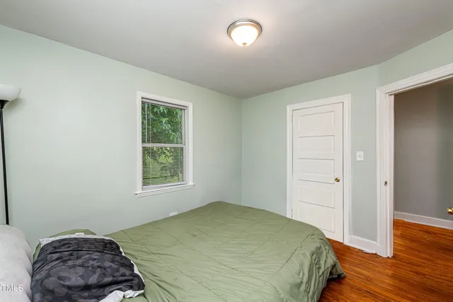 a bedroom with a bed and wooden floor