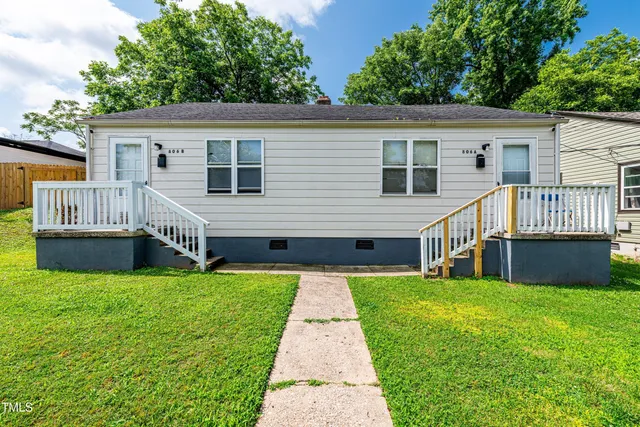 a view of a house with a yard and deck