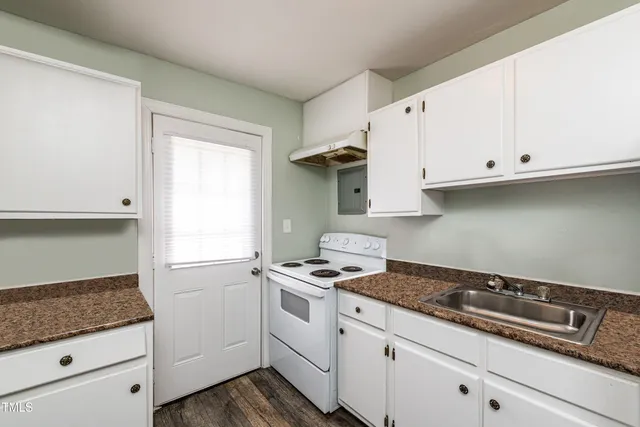 a kitchen with granite countertop white cabinets and white appliances