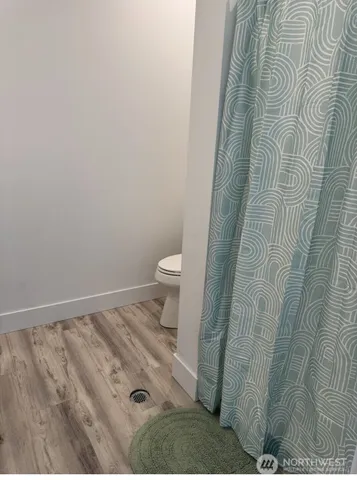 a bathroom with a toilet and a shower curtain