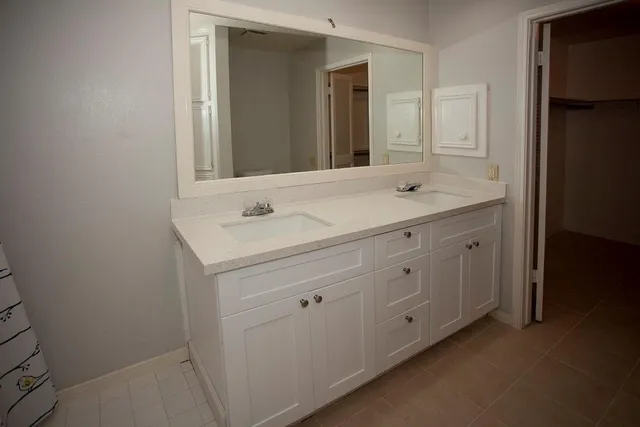 a bathroom with a double vanity sink and mirror