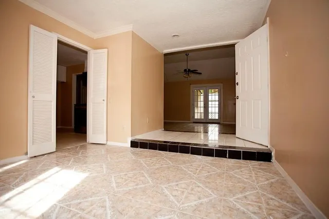 a view of a hallway with wooden floor and a living room