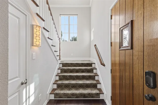 a view of staircase with lots of frames on wall and a window