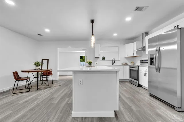 a kitchen with white cabinets and stainless steel appliances