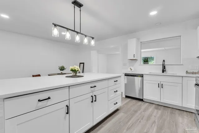 a kitchen with sink cabinets and wooden floor