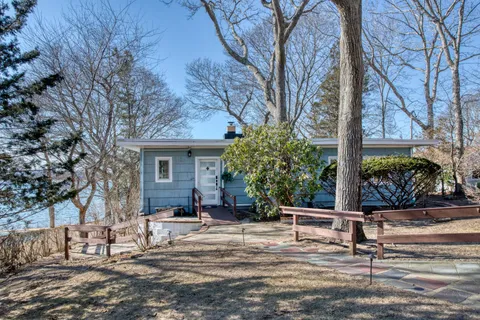 a view of a house with backyard and trees