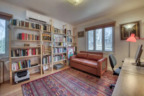a living room with furniture and a book shelf