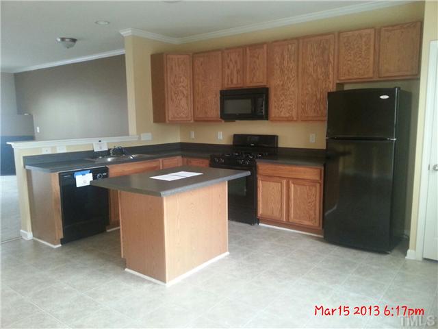14411 Hamletville Street Raleigh, NC 27614 - Photo 4 of 16 a kitchen with a sink stove and refrigerator