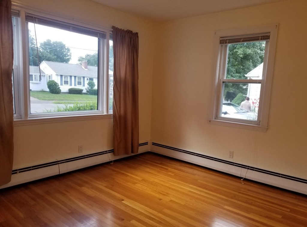 50 Marion Road, Unit 1 Arlington, MA 02474 - Photo 3 of 8 an empty room with wooden floor and windows