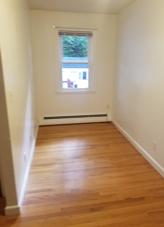 50 Marion Road, Unit 1 Arlington, MA 02474 - Photo 7 of 8 a view of an empty room with wooden floor and a window