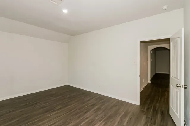 a view of a room with wooden floor and a ceiling fan
