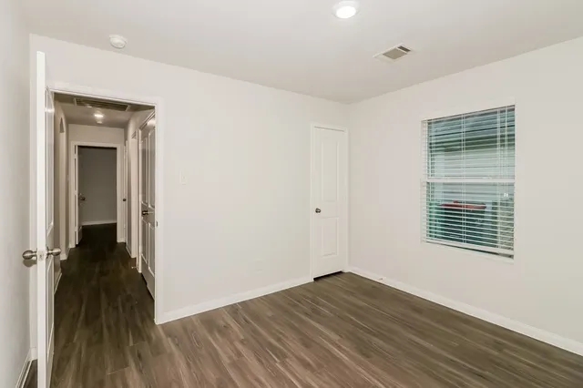 a view of a room with wooden floor and a window