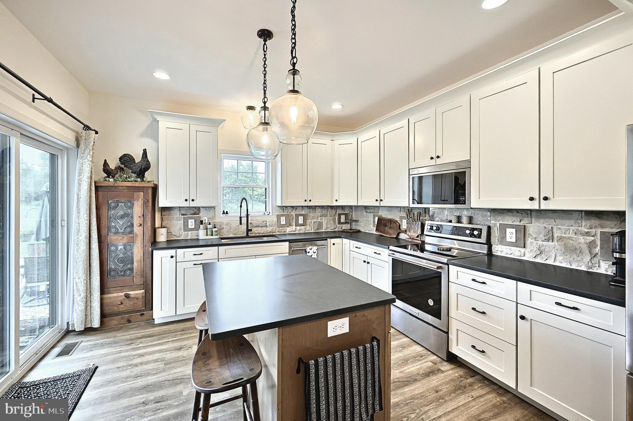 4575 Lewisberry Road York, PA 17404 - Photo 23 of 56 a kitchen with stainless steel appliances granite countertop a refrigerator a sink dishwasher a stove and white cabinets with wooden floor