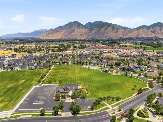 877 South Yarrow Drive Mapleton, UT 84664 - Photo 40 of 46 Aerial perspective showcasing a residential community with expansive green spaces and mountainous backdrops