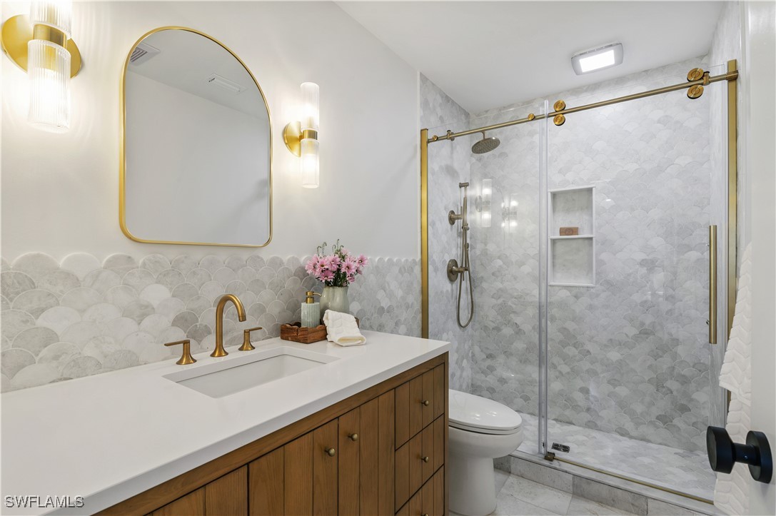 1411 Beach Cottages, Unit 1411 Captiva, FL 33924 - Photo 19 of 40 a bathroom with a sink a toilet and shower