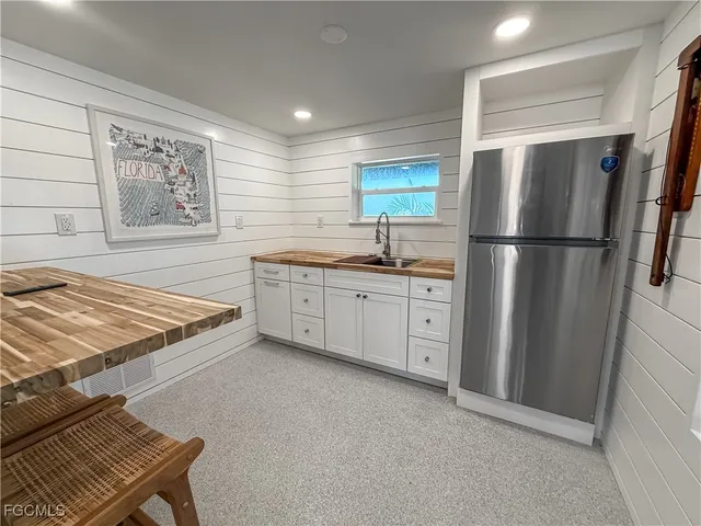 a kitchen with stainless steel appliances a refrigerator sink and white cabinets