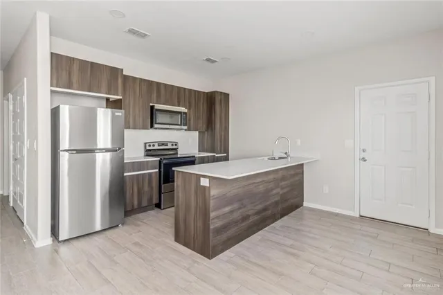 a kitchen with stainless steel appliances a refrigerator and a stove