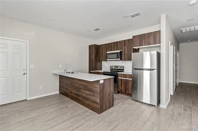 a kitchen with stainless steel appliances a refrigerator and a stove
