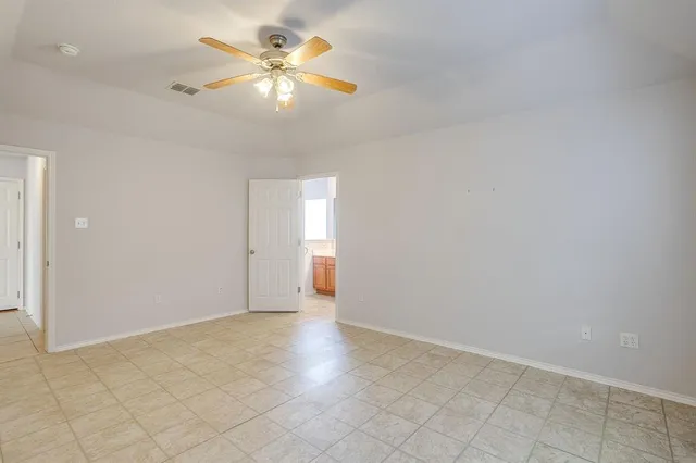 an empty room with chandelier fan