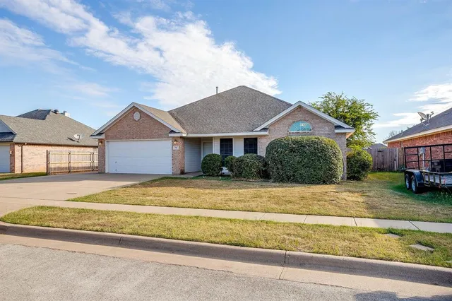 a view of a house with a patio and a yard
