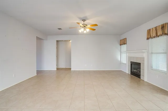 a view of an empty room with window and fire place