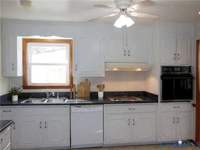 a kitchen with granite countertop white cabinets and black appliances
