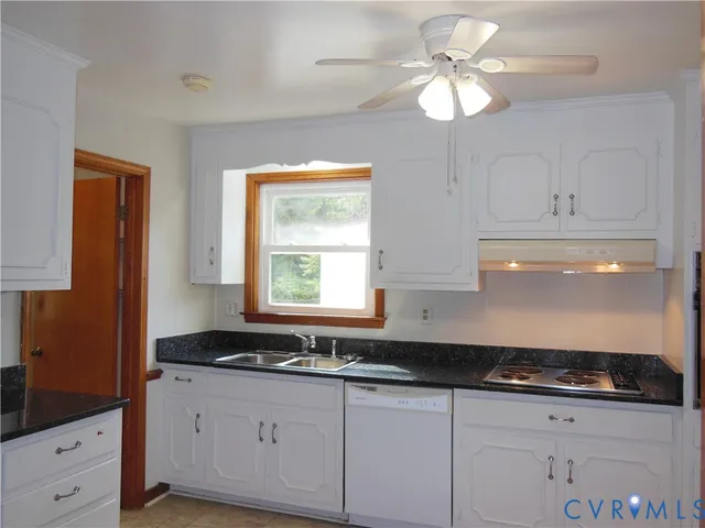 a kitchen with granite countertop white cabinets and a sink