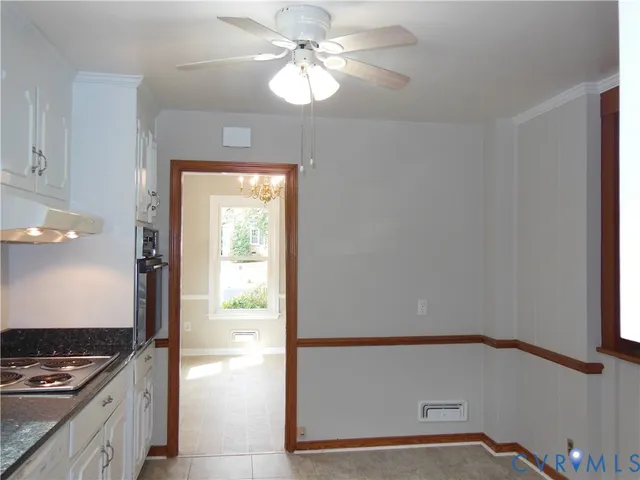 a kitchen with a window a ceiling fan and a stove