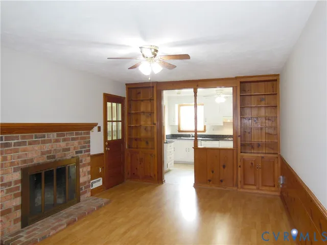 a view of an empty room with a fireplace and a window