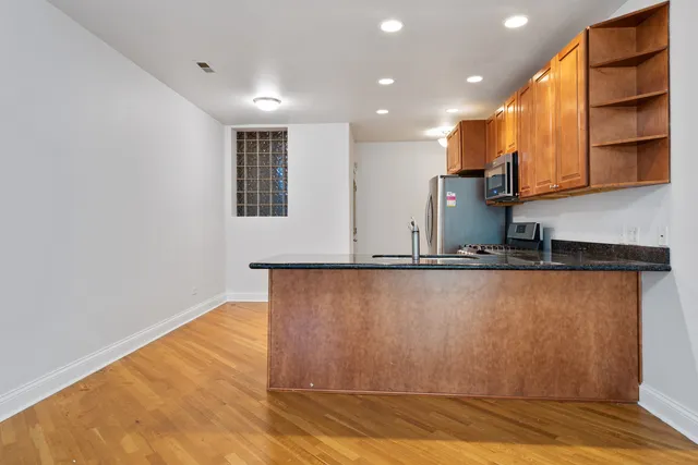 a view of kitchen with stainless steel appliances granite countertop a refrigerator and a stove top oven