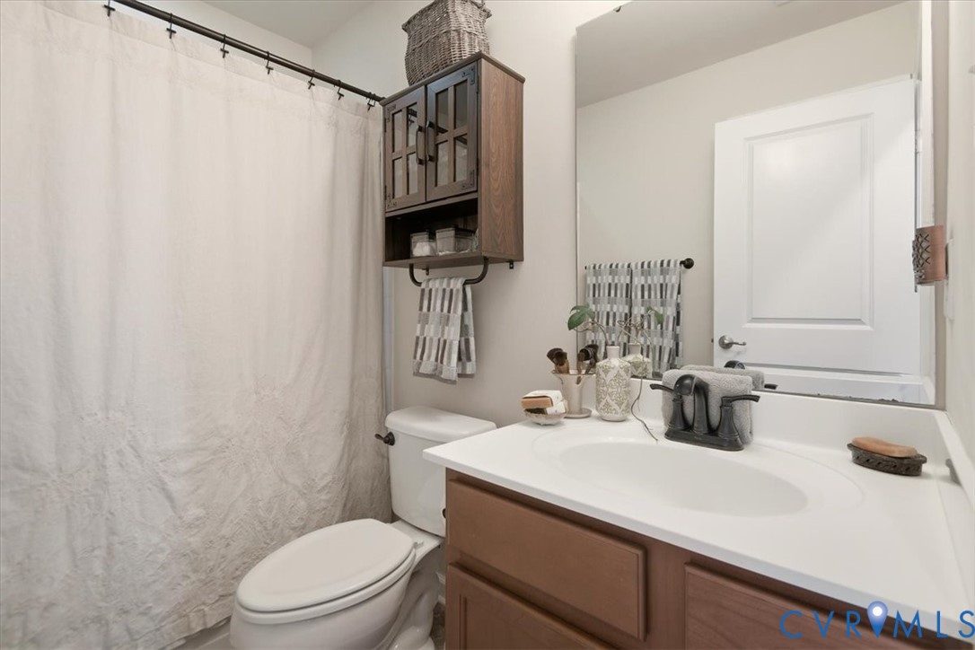 4836 Skyline Ridge Drive Midlothian, VA 23112 - Photo 32 of 44 a bathroom with a sink a toilet and shower curtain