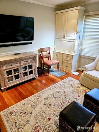 a living room with a rug and a flat screen tv