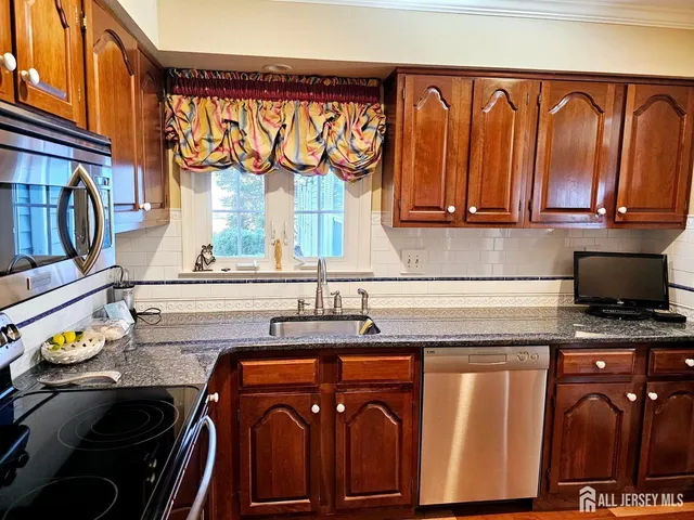 a kitchen with stainless steel appliances granite countertop a stove and a microwave