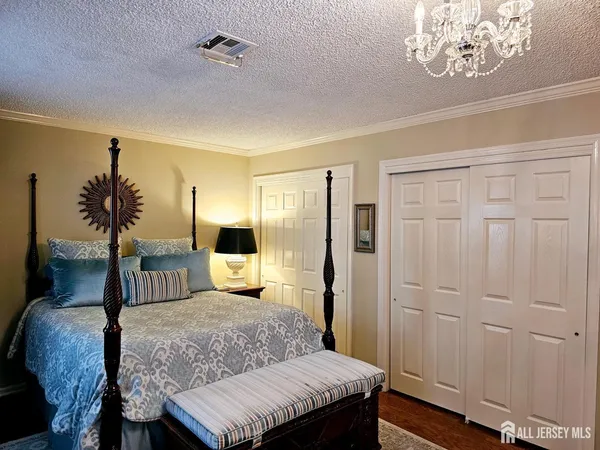 a bedroom with a large bed and a chandelier