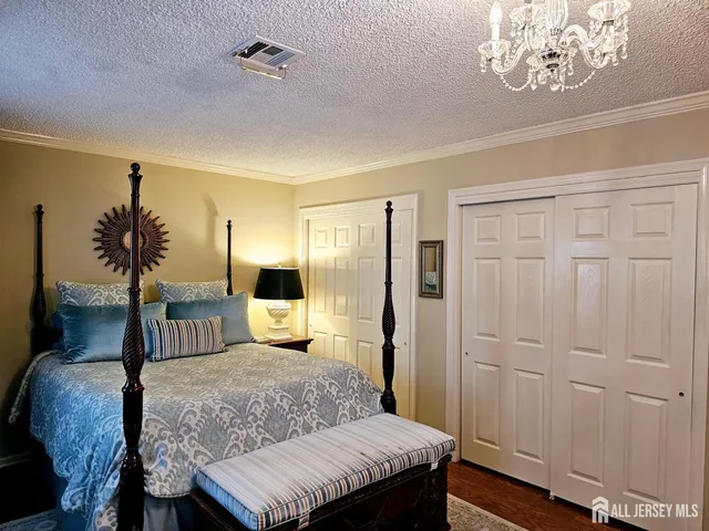 a bedroom with a large bed and a chandelier