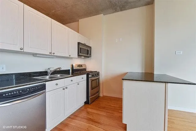 a kitchen with stainless steel appliances granite countertop a sink and a stove
