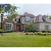 a view of a house with a big yard plants and large trees