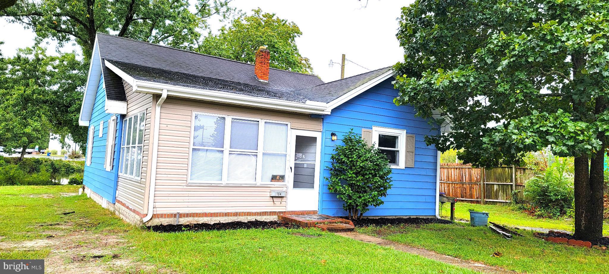 Charming two-tone home with lush greenery.