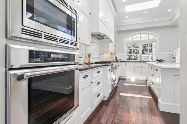 a living room with furniture a wooden floor and a potted plant