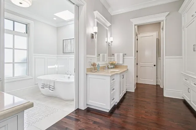 a kitchen with stainless steel appliances kitchen island granite countertop a table chairs in it and wooden floors