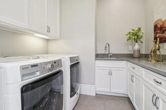 a front view of a house with a garden and trees