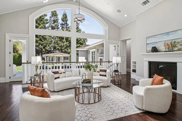 a view of a hallway with wooden floor and a living room